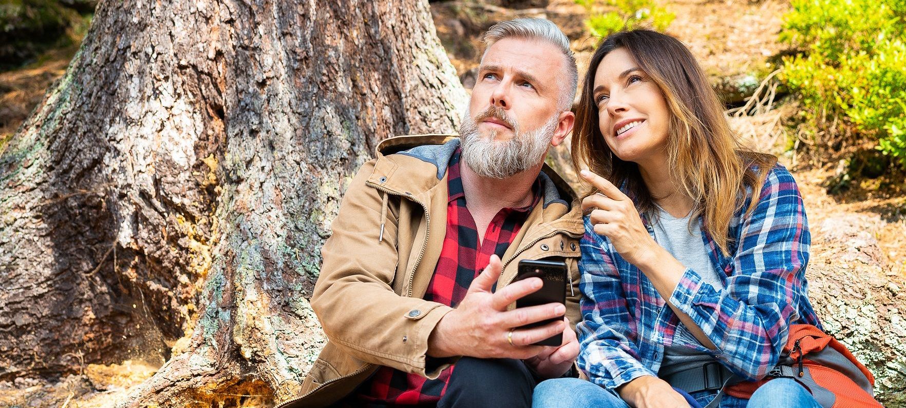 Frau und Mann mit Smartphone im Wald